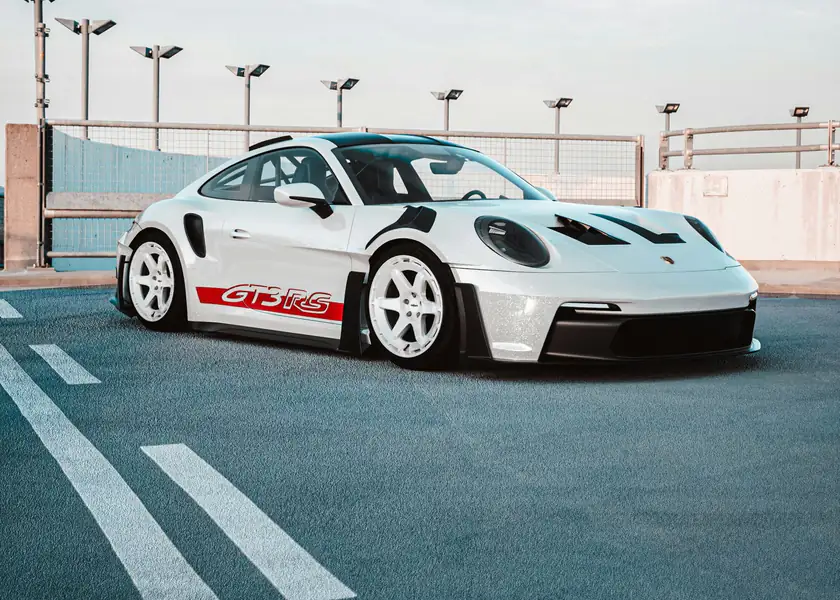 A white Porsche 911 GT3 RS parked on a rooftop deck